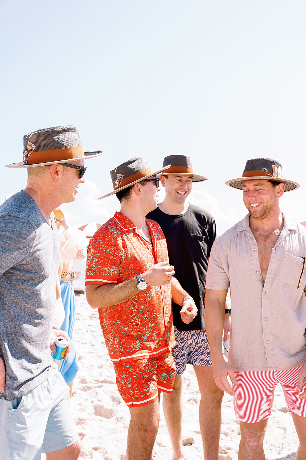 Groomsmen laughing together on the beach during a relaxed destination wedding weekend