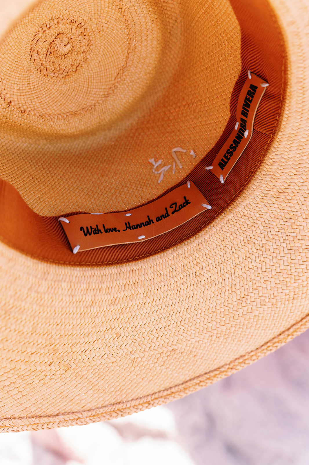 Close-up of a custom straw hat with personalized wedding message inside