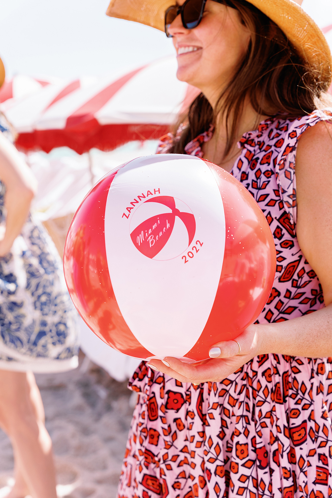 Wedding guest holding a custom beach ball during a destination wedding beach party
