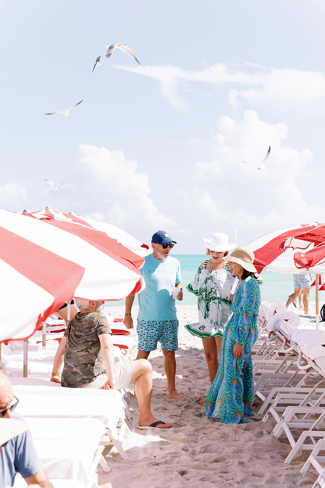 Wedding guests socializing between beach chairs at a Faena destination wedding weekend