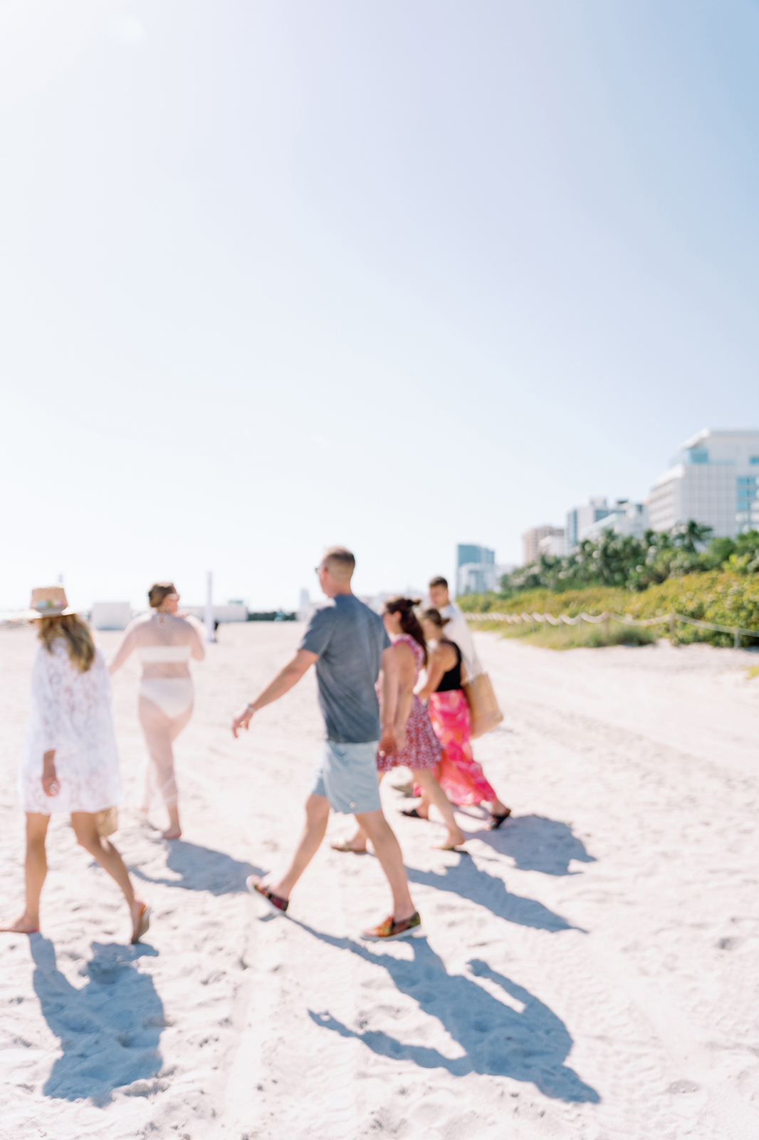 Wedding guests walking along Faena Beach in Miami during a relaxed destination wedding celebration