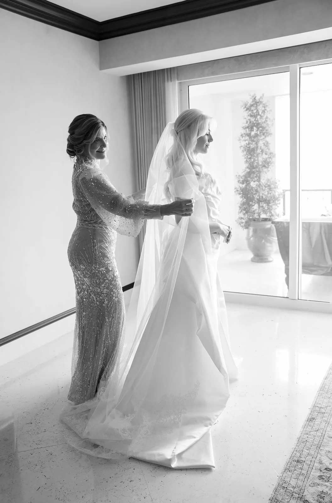 Mother helping bride with her veil during getting ready moments at a Fisher Island wedding