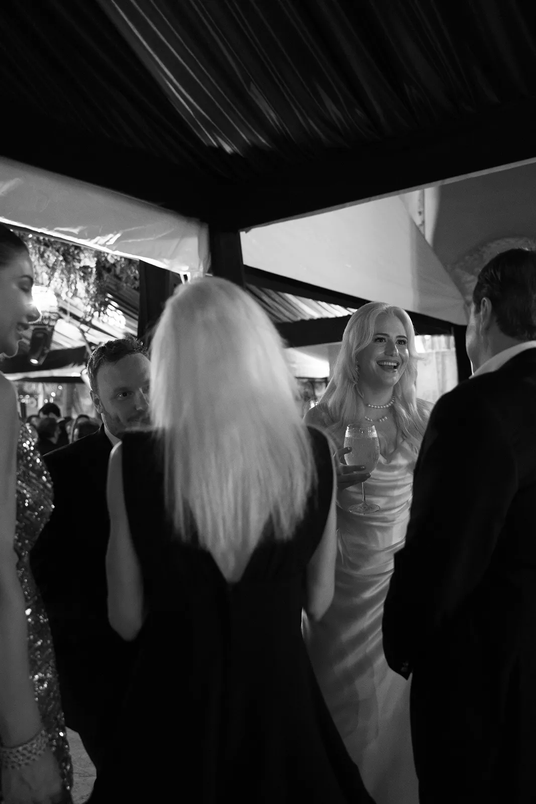 Guests mingling during Fisher Island wedding cocktail hour, candid black and white reception moment