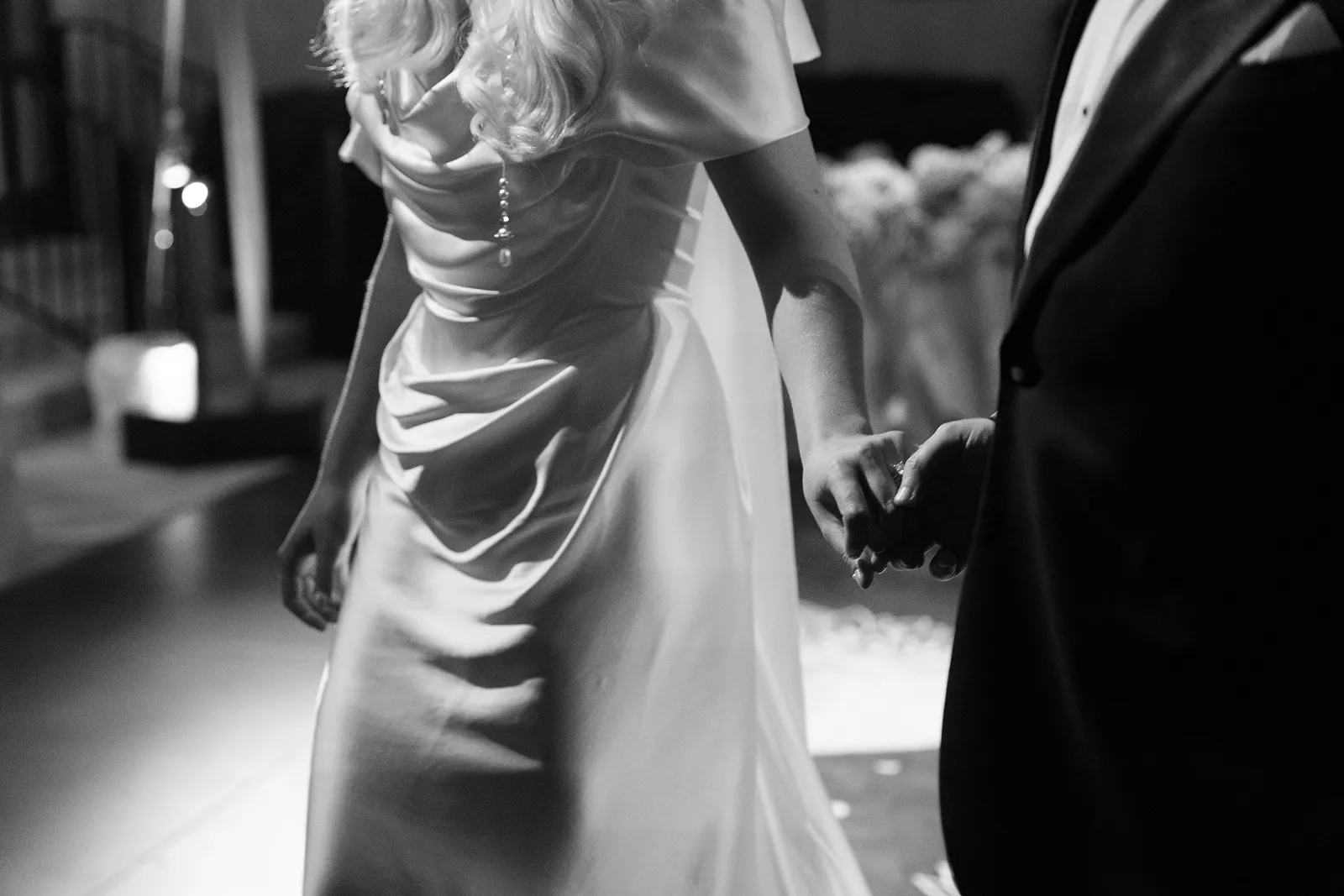 close-up of bride and groom holding hands