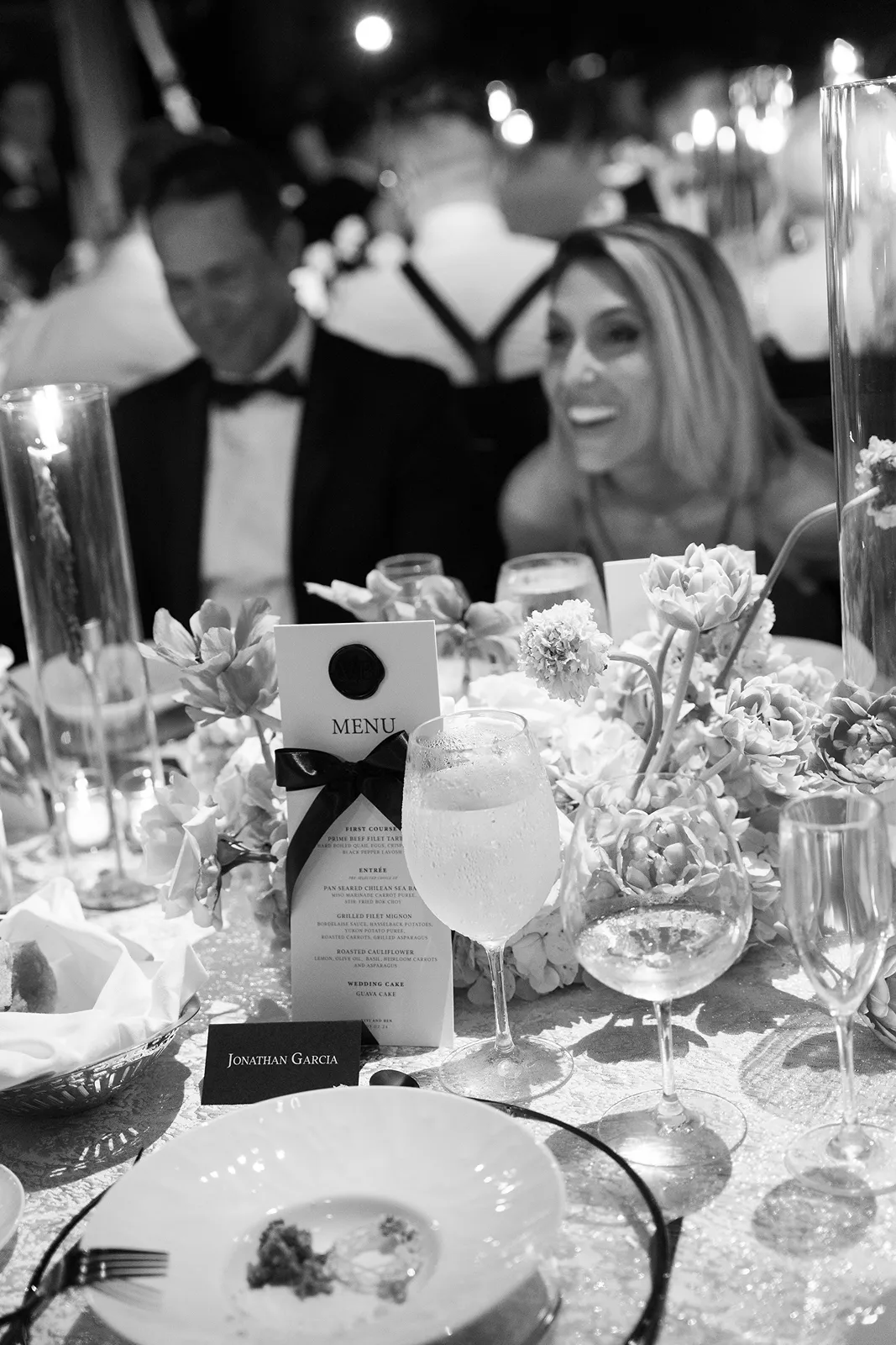 Wedding reception table with menus, glassware, and floral details at Fisher Island Club