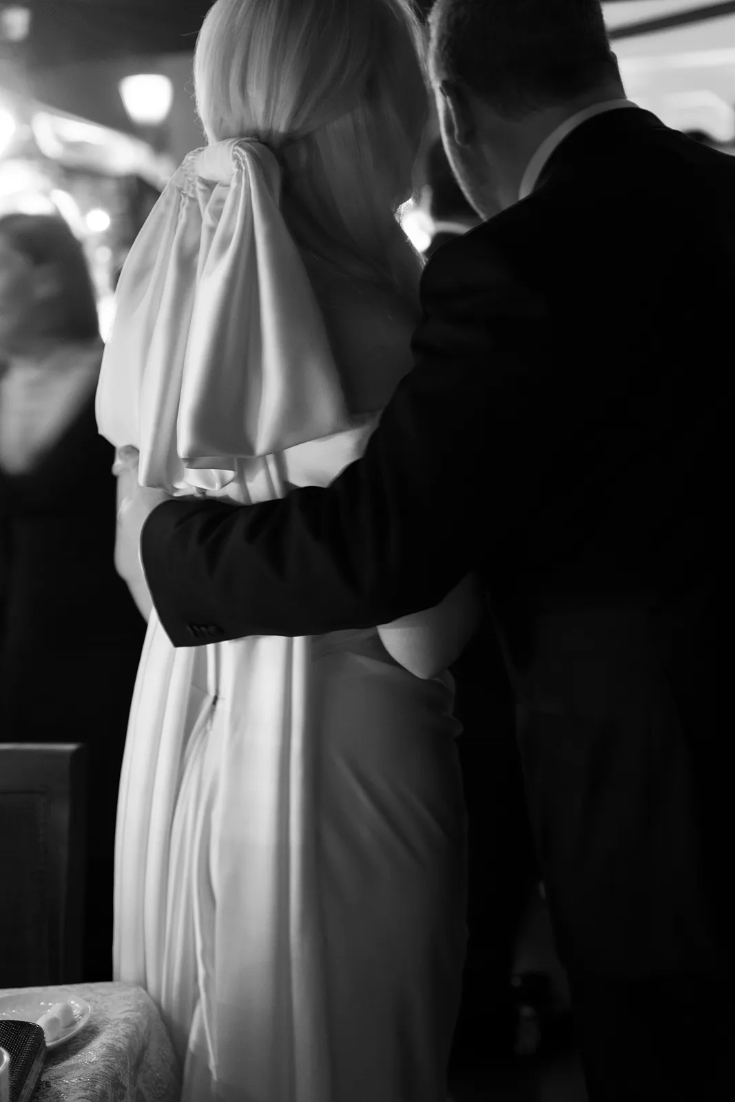 Emotional black and white moment of a bride and groom standing together during the reception