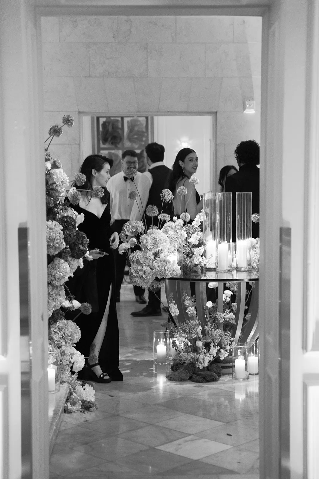 Guests gathered among lush floral arrangements and candlelight during an elegant evening reception