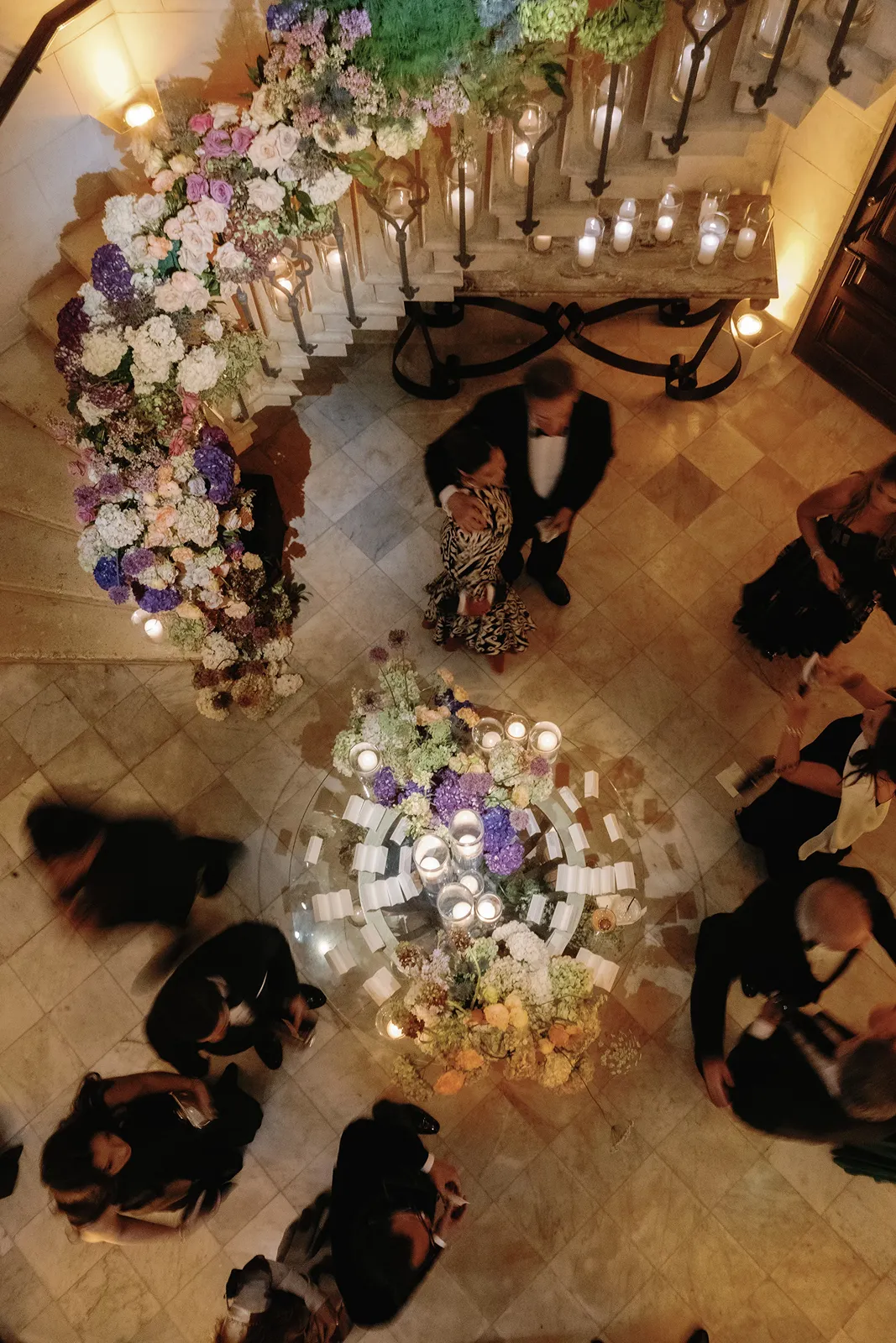 Overhead view of wedding cocktail hour with floral installations, candles, and guests mingling at fisher island