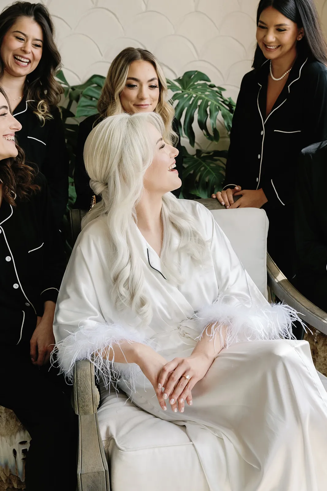 Bride laughing with bridesmaids during getting ready portraits in matching black pajamas