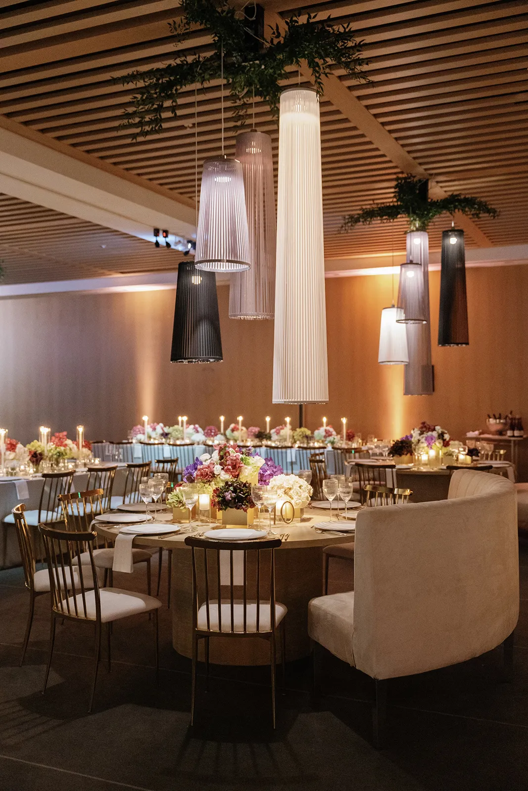 Modern wedding reception space with candlelit tables and hanging pendant lights at the Miami Beach EDITION