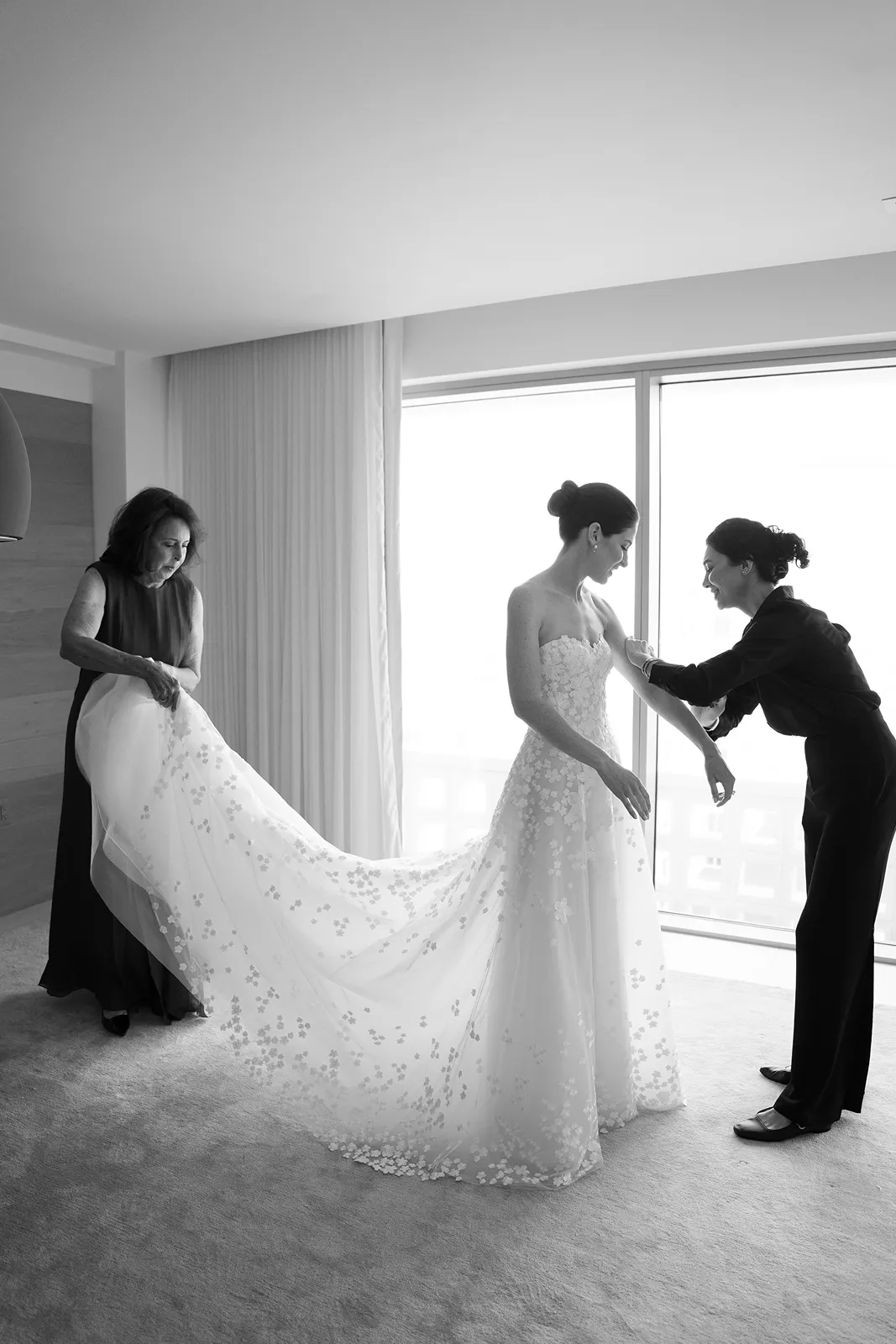 Bride getting ready with family members adjusting her wedding dress at The Miami Beach EDITION