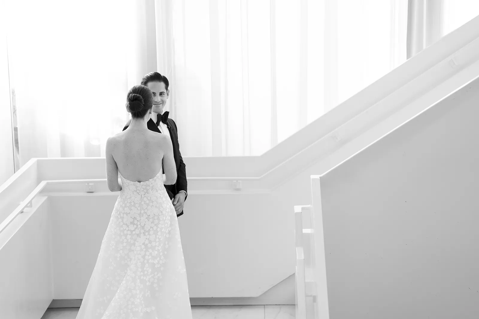Bride and groom sharing a quiet first look on a minimalist white staircase at the Miami Beach EDITION
