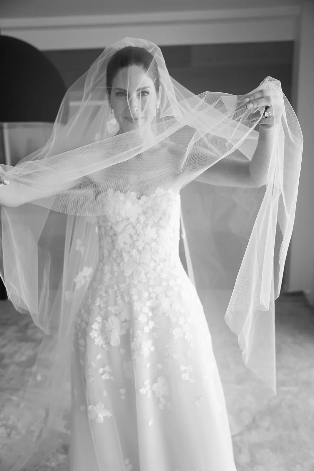 Bride holding her veil up during a timeless black and white bridal portrait