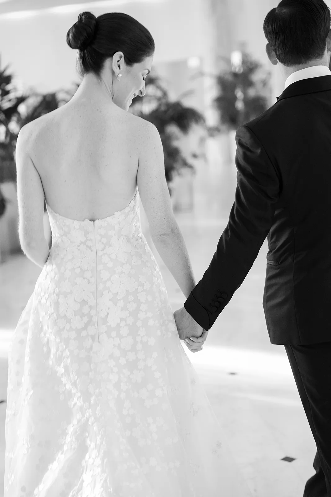 Bride and groom walking hand in hand inside The Miami Beach EDITION