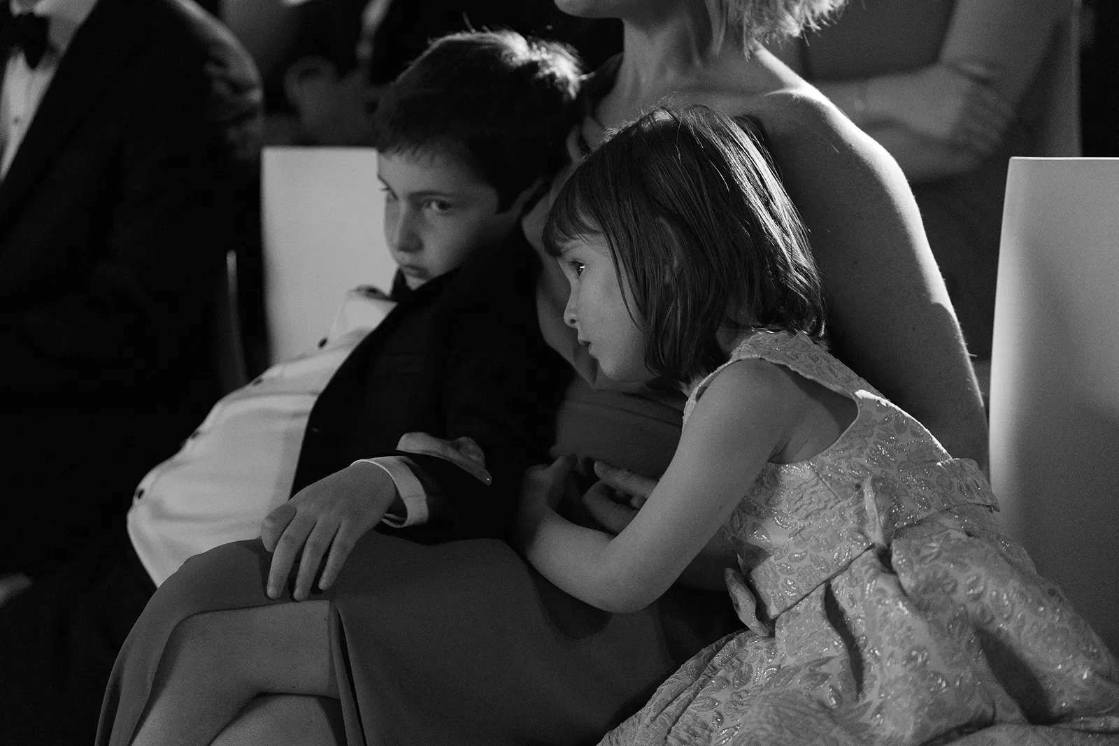 Children resting with family during the wedding during the ceremony