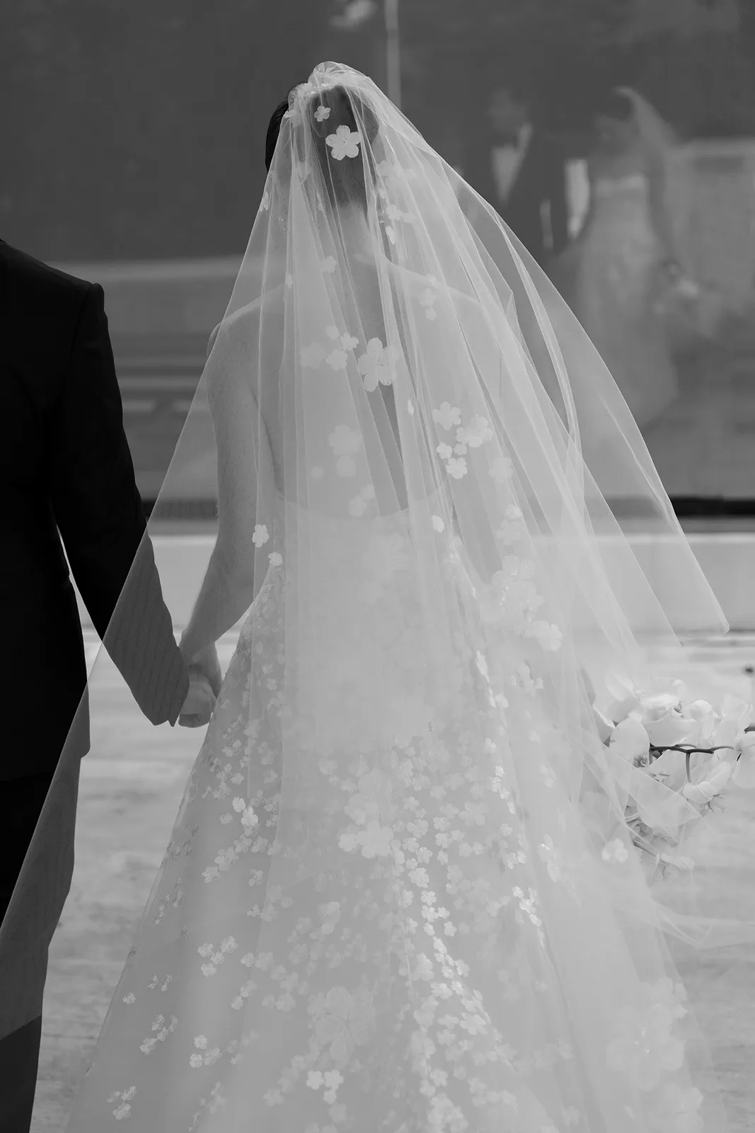 Bride walking with groom, veil flowing, at The Miami Beach EDITION