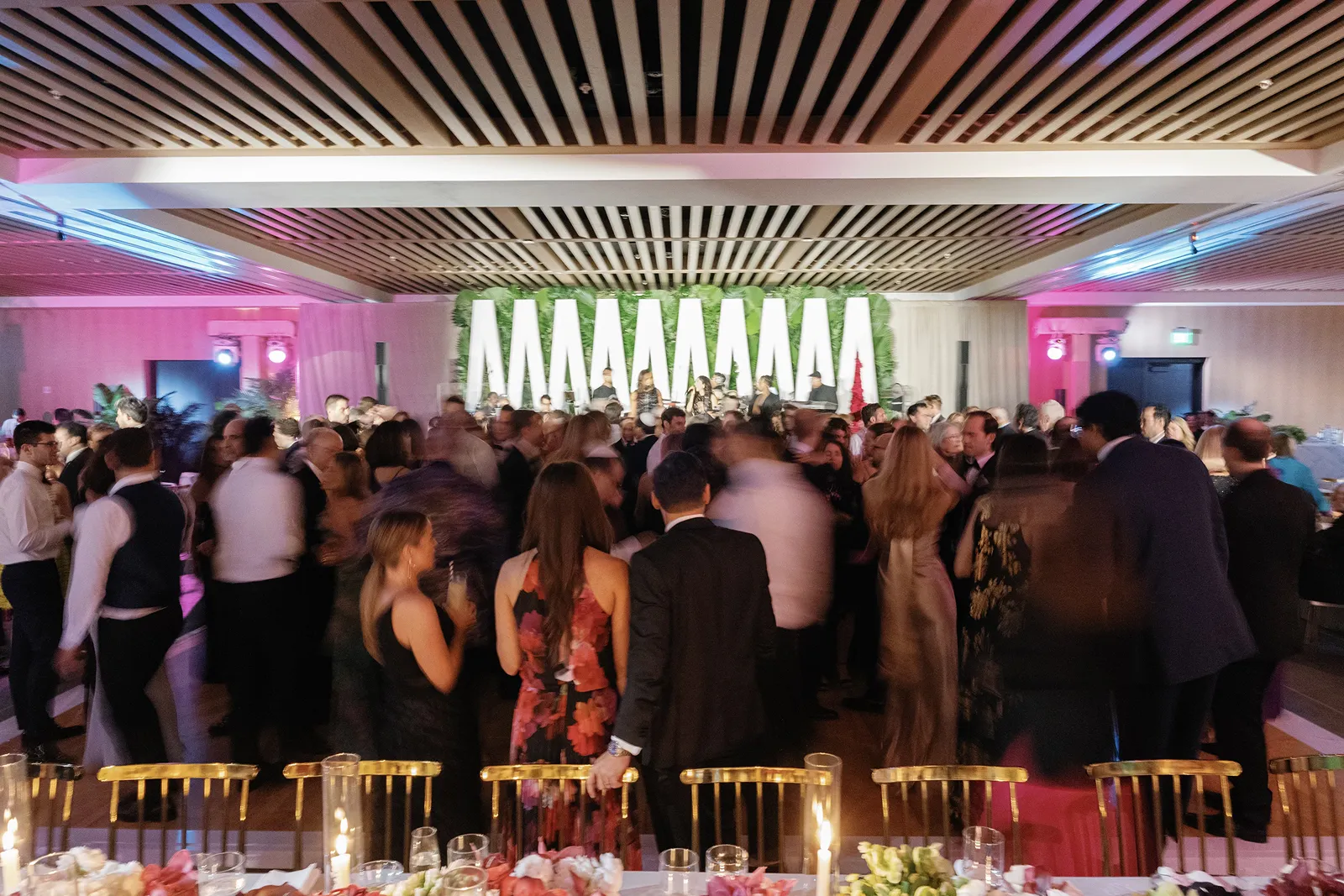 Wedding guests filling the dance floor during a lively reception celebration with live music