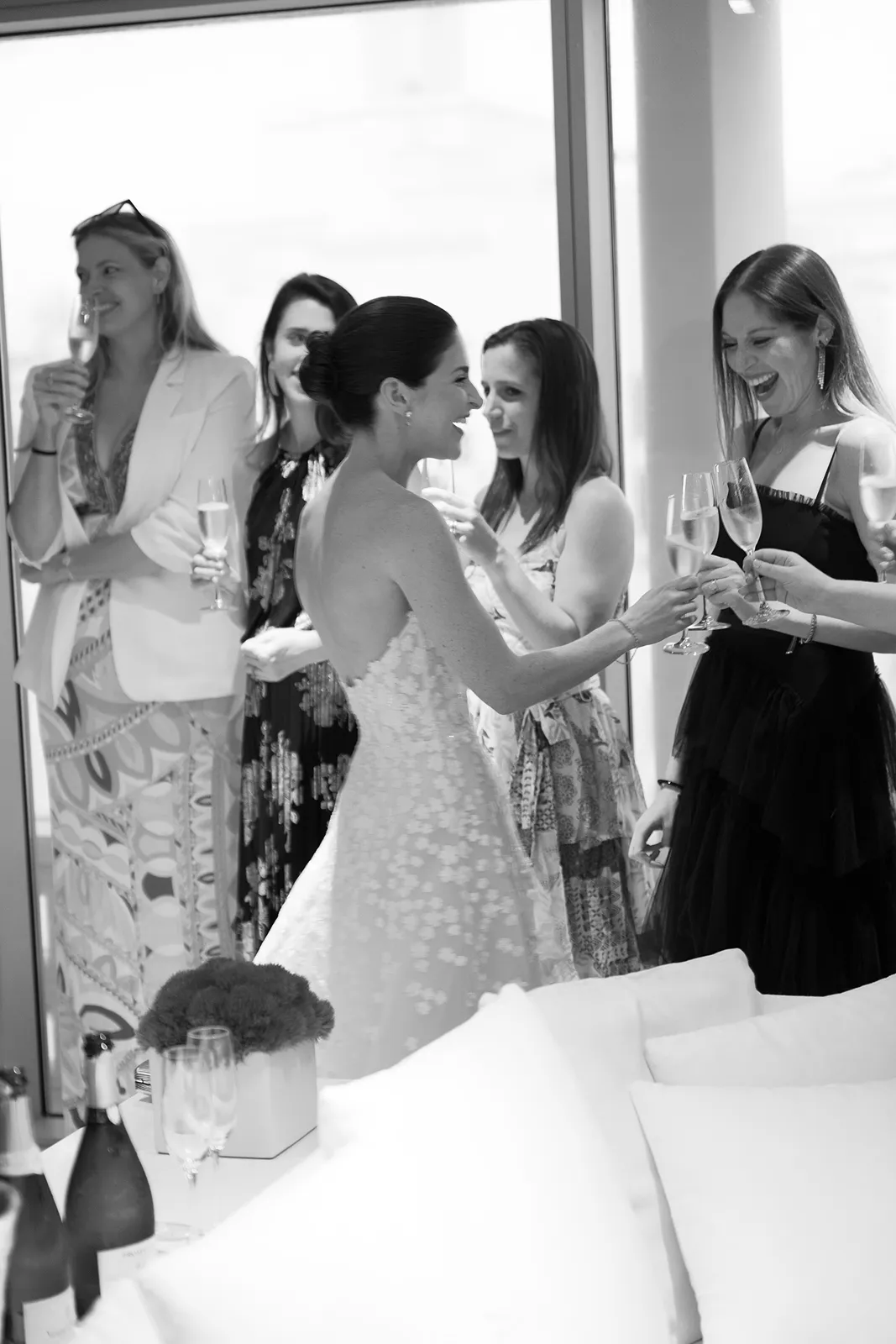 Bride clinking champagne glasses with close friends during an intimate pre-reception toast