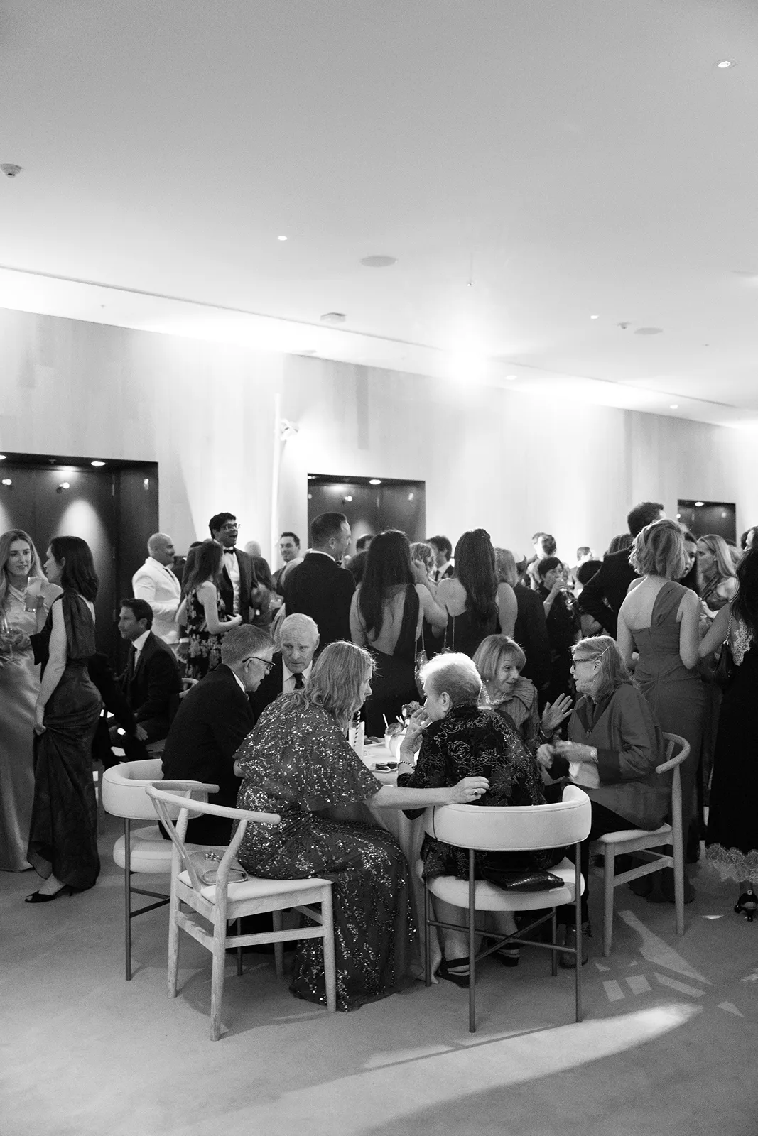 Wedding guests gathered and chatting during a lively cocktail hour indoors