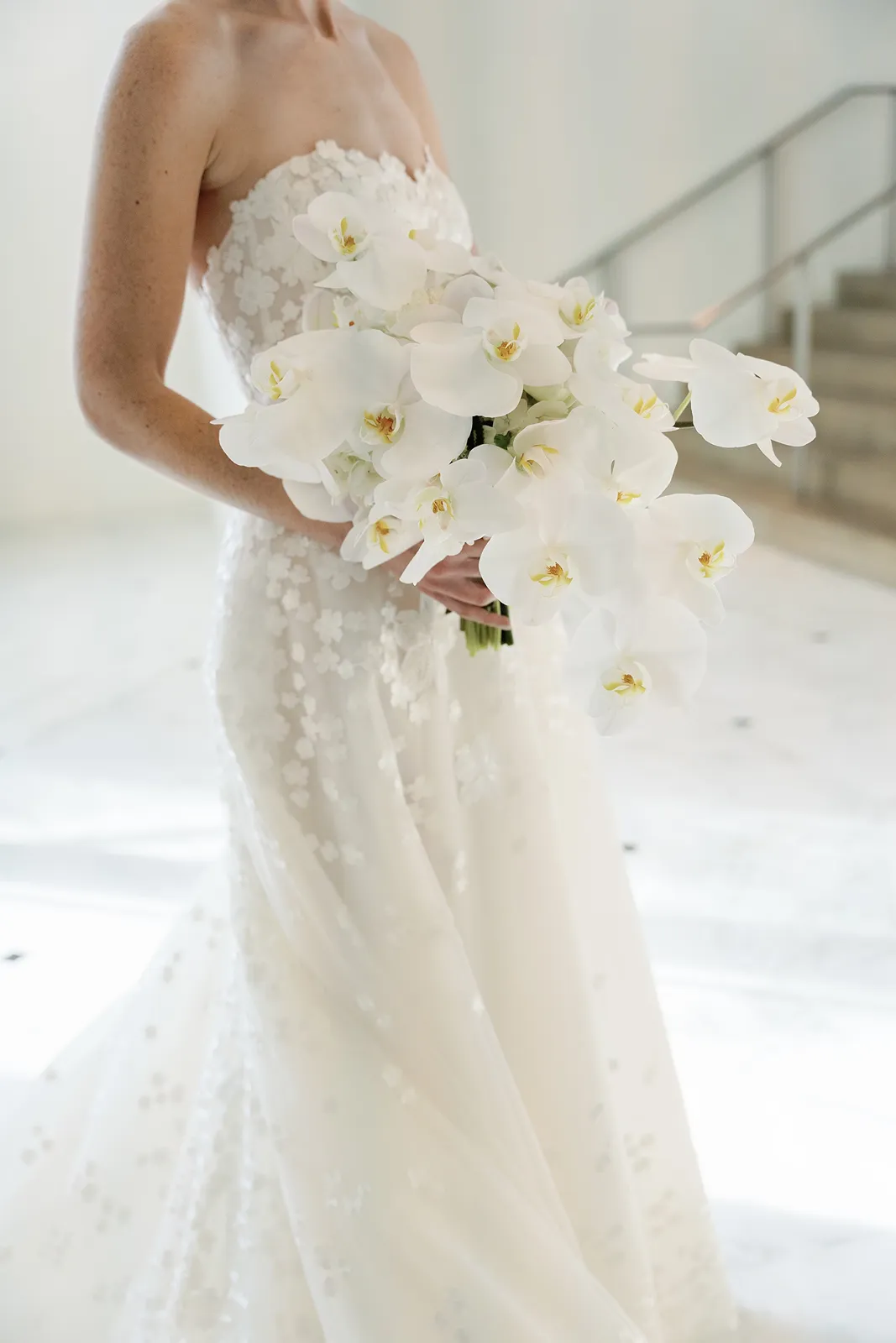 Bride holding a cascading white orchid bouquet during portraits at The Miami Beach EDITION