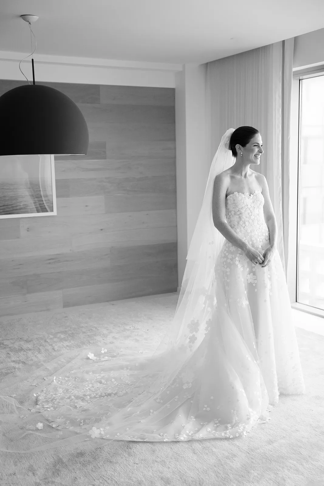 Bride standing by a large window in her wedding gown during a quiet moment at The Miami Beach EDITION