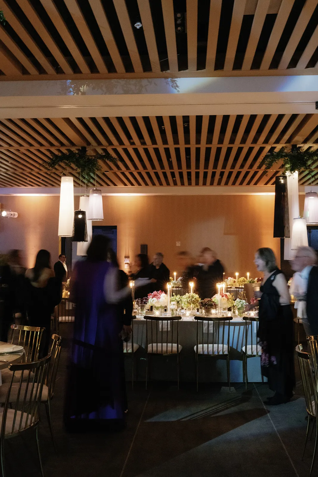 Guests mingling around candlelit wedding reception tables at The Miami Beach EDITION
