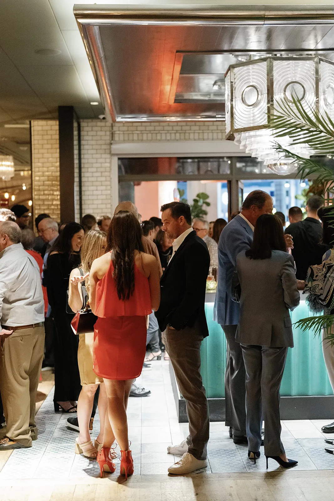 Guests socializing and chatting near the bar during a lively Miami Beach rehearsal dinner