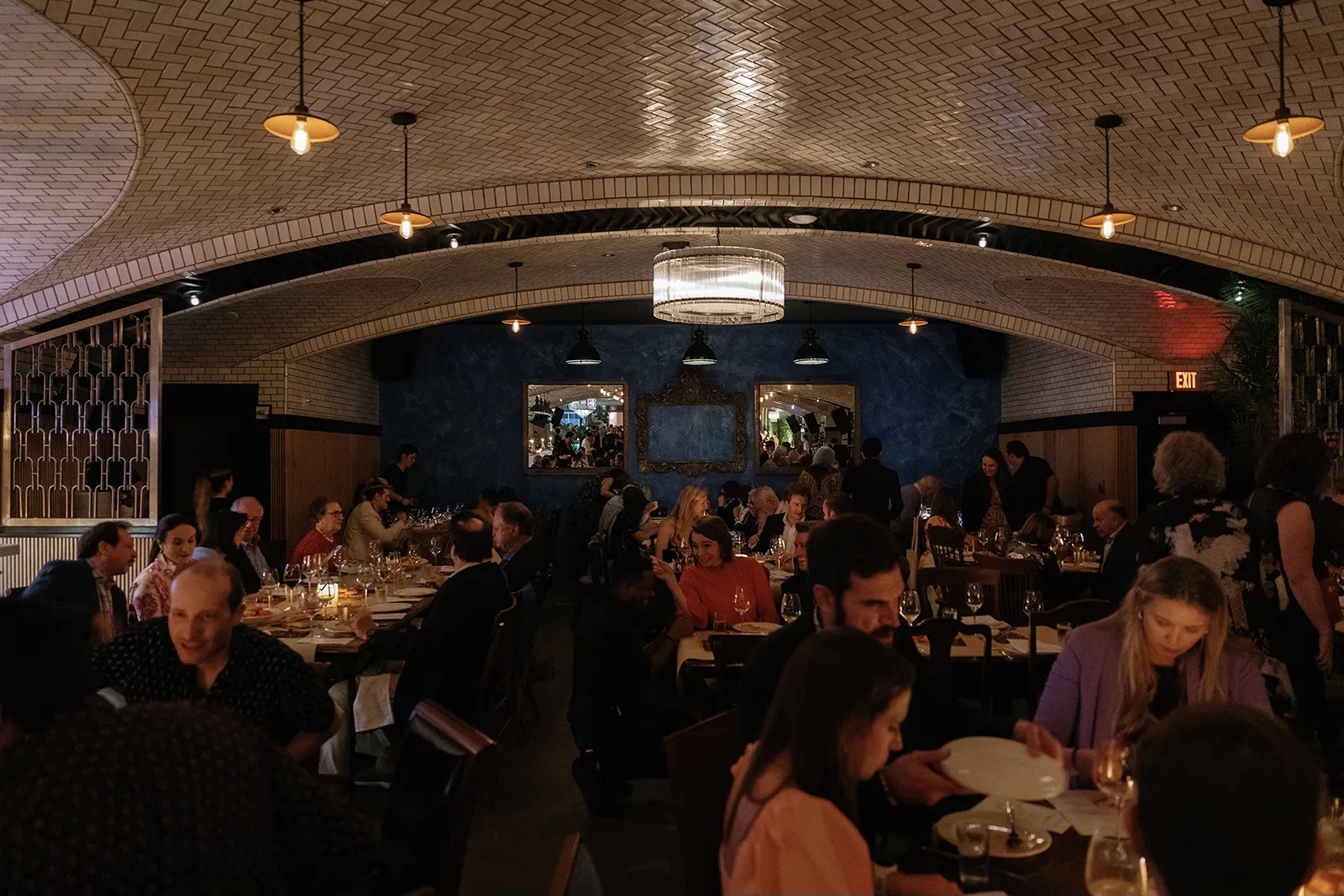 Guests seated at candlelit tables inside Hasalon Miami Beach during the wedding rehearsal dinner