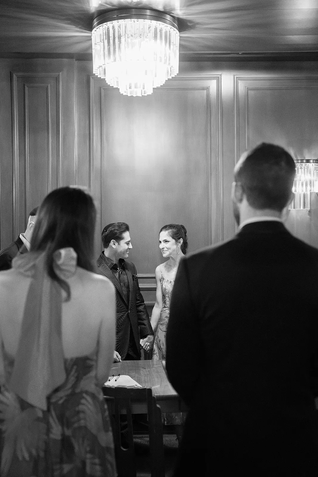 Couple holding hands during an intimate rehearsal dinner ceremony at Hasalon Miami Beach