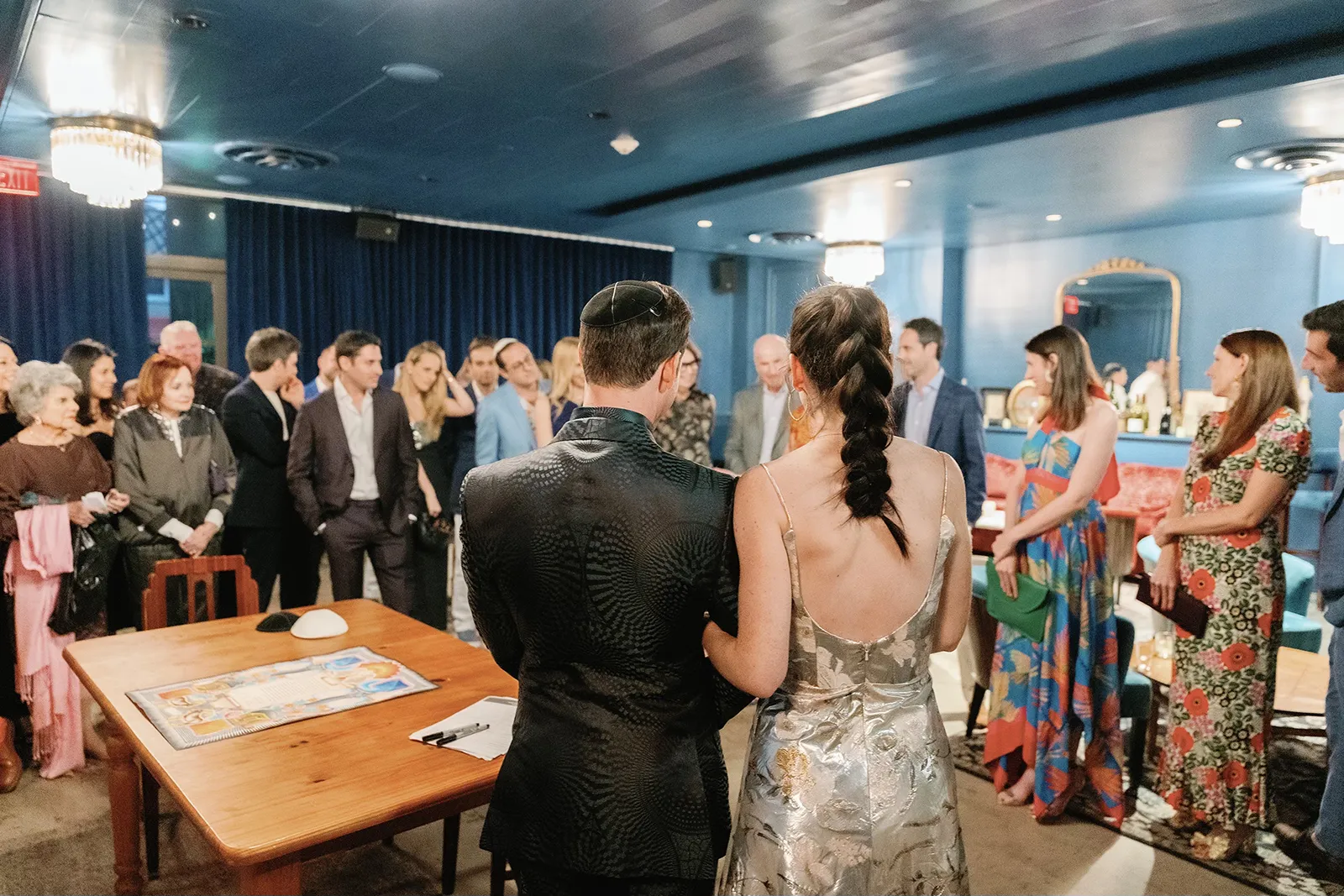 Guests gathered around the signing table during a rehearsal dinner