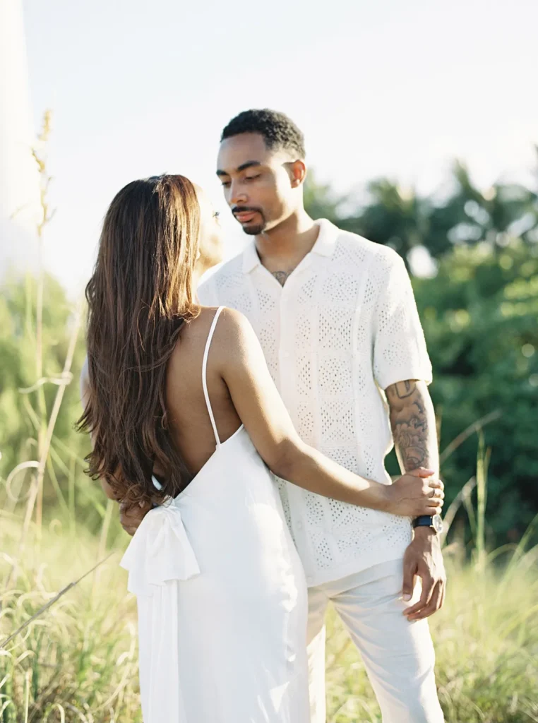 bride holding fiancé's arm during sunset portraits