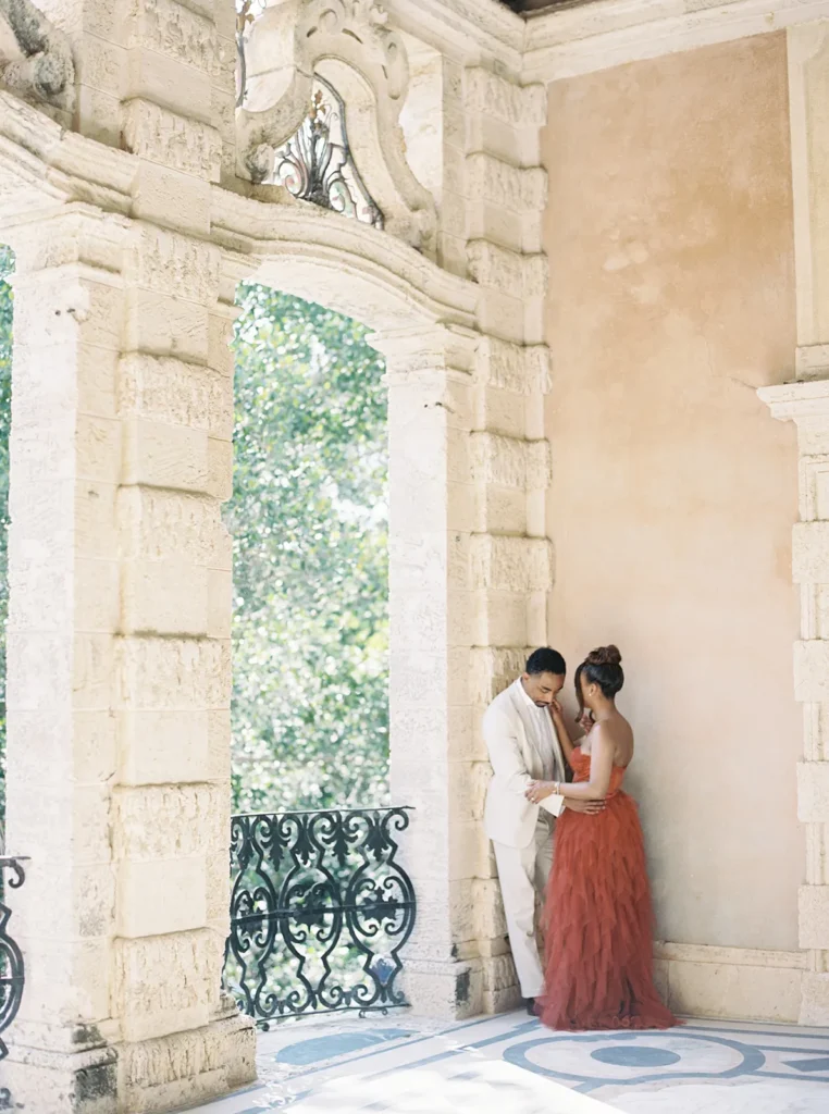 couple hugging in a corner of a building in vizcaya museum