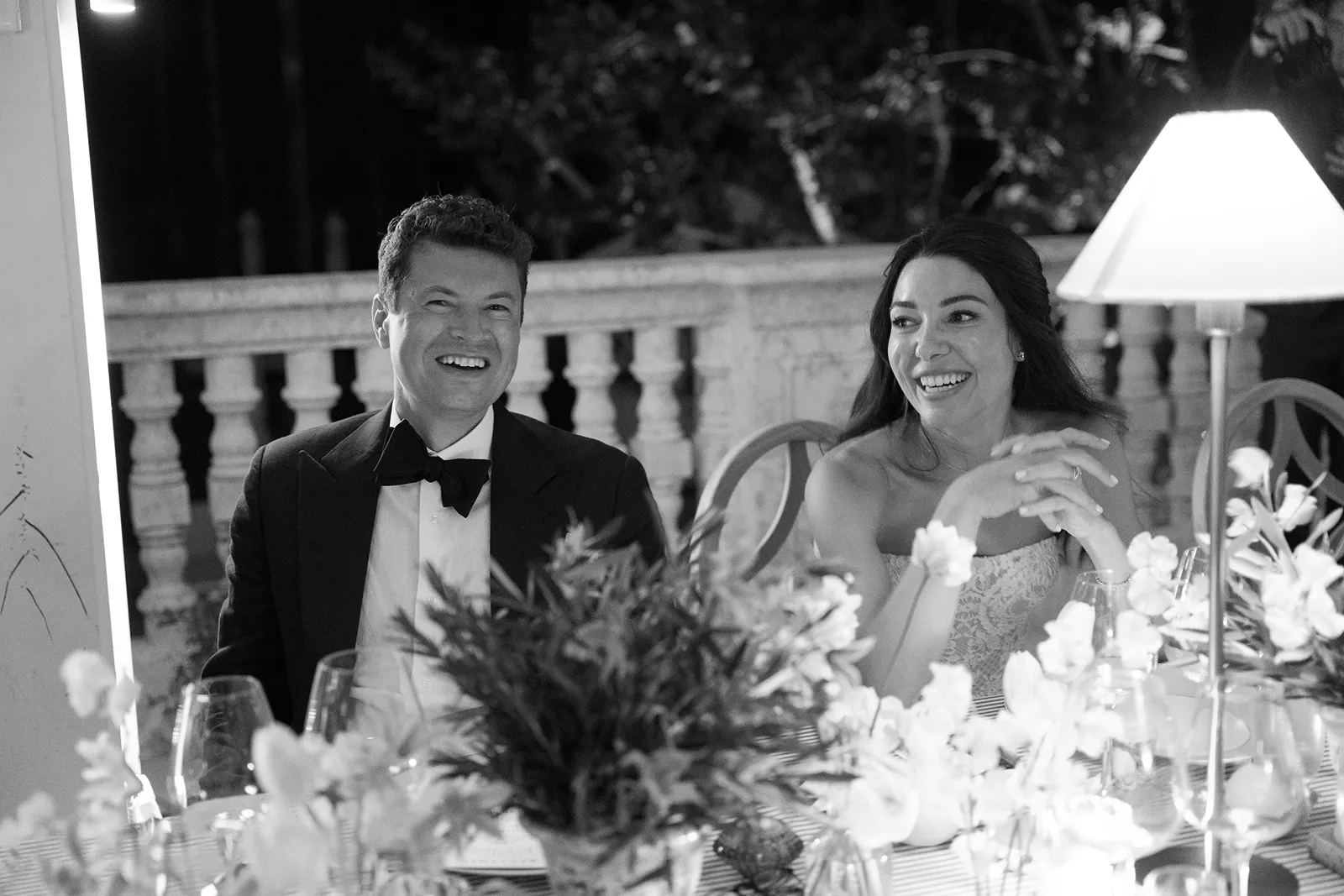 couple sitting and laughing to wedding toasts