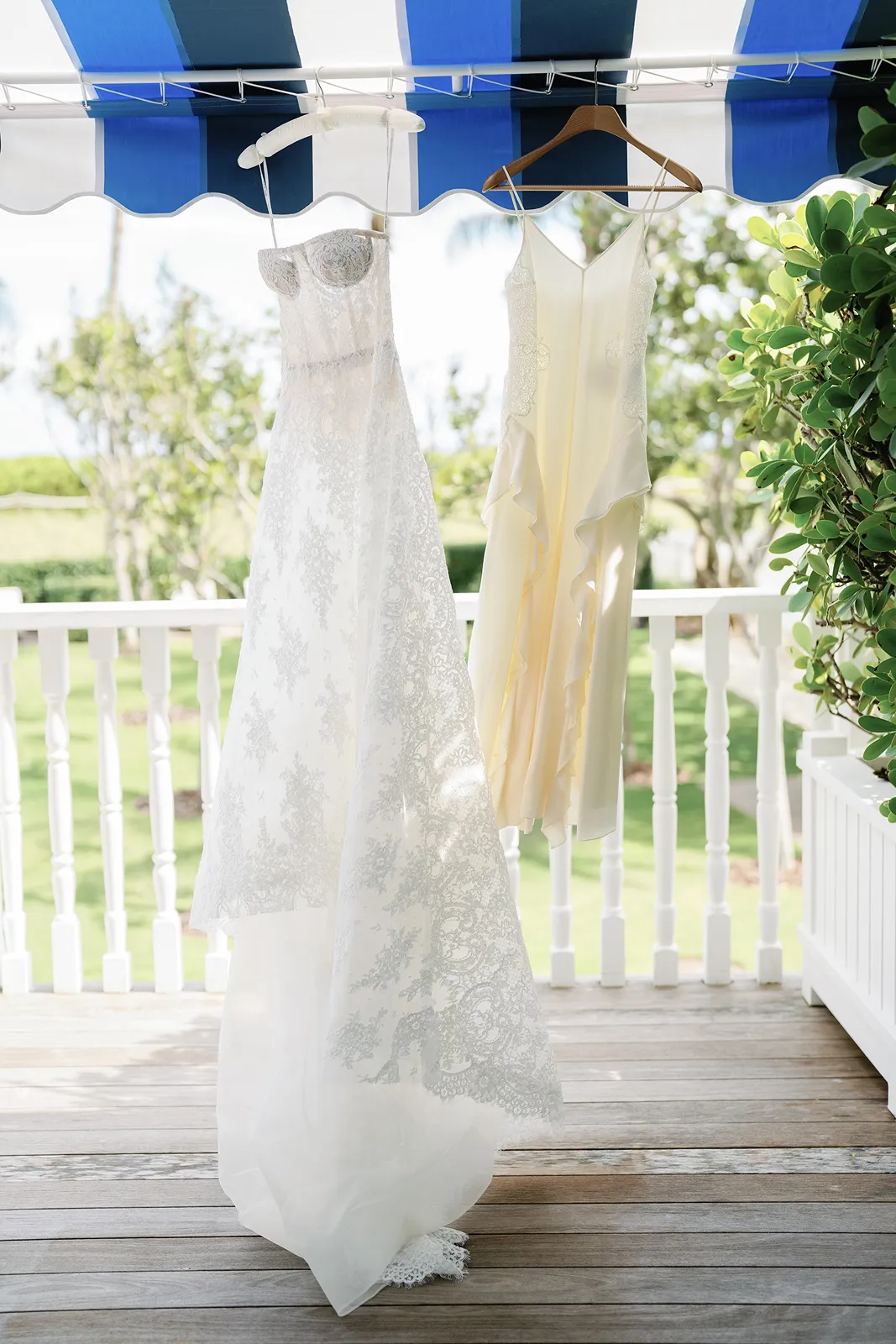 bride's wedding gown and after party dress hanging in the bungalow