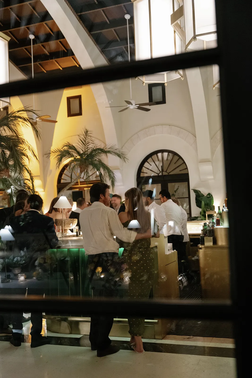 a couple standing near the bar waiting for their drink