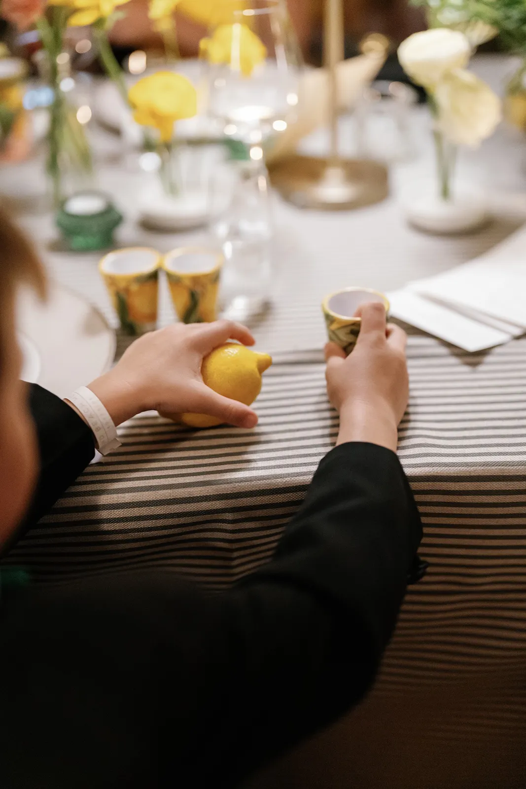 close up of a ring boy playing with the reception decorations which is a lemon and a cup