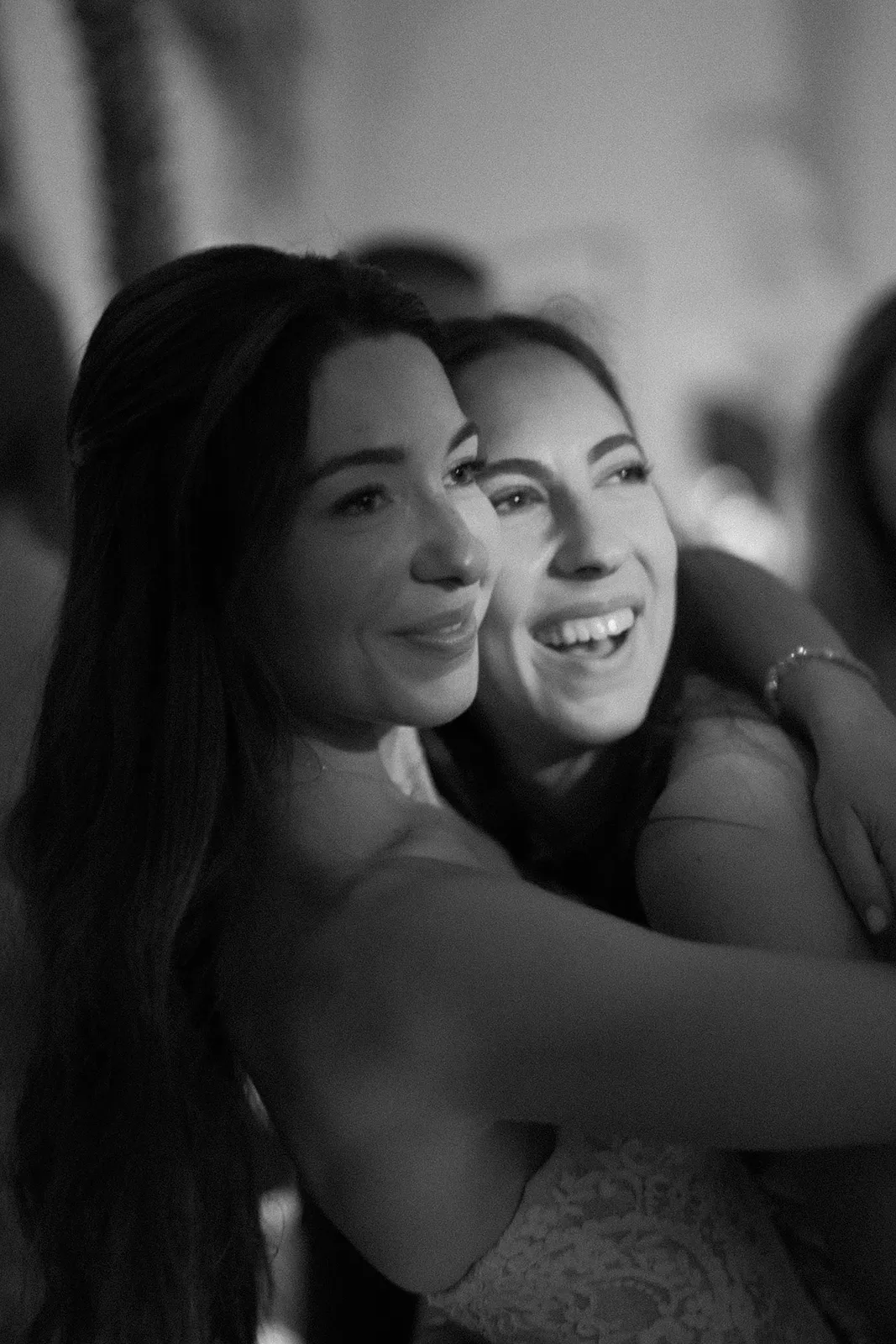 close up of bride hugging her best friend on the dance floor