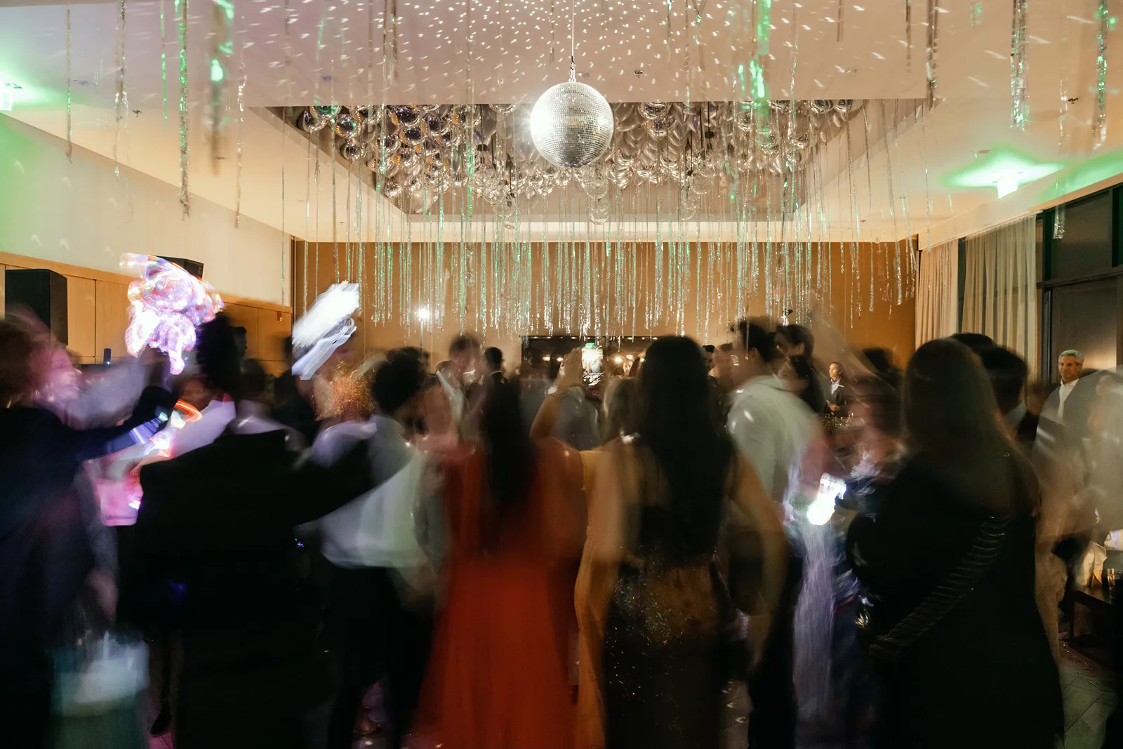 Crowded dance floor under disco ball lighting at a Montage Healdsburg wedding reception