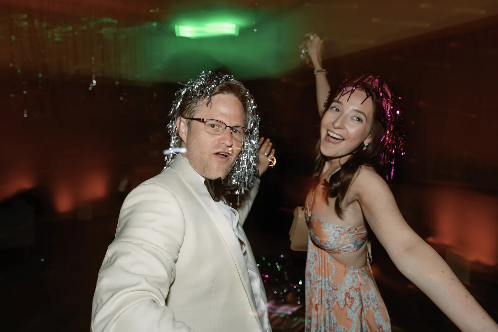 Wedding guests dancing and taking a selfie during a lively after party celebration