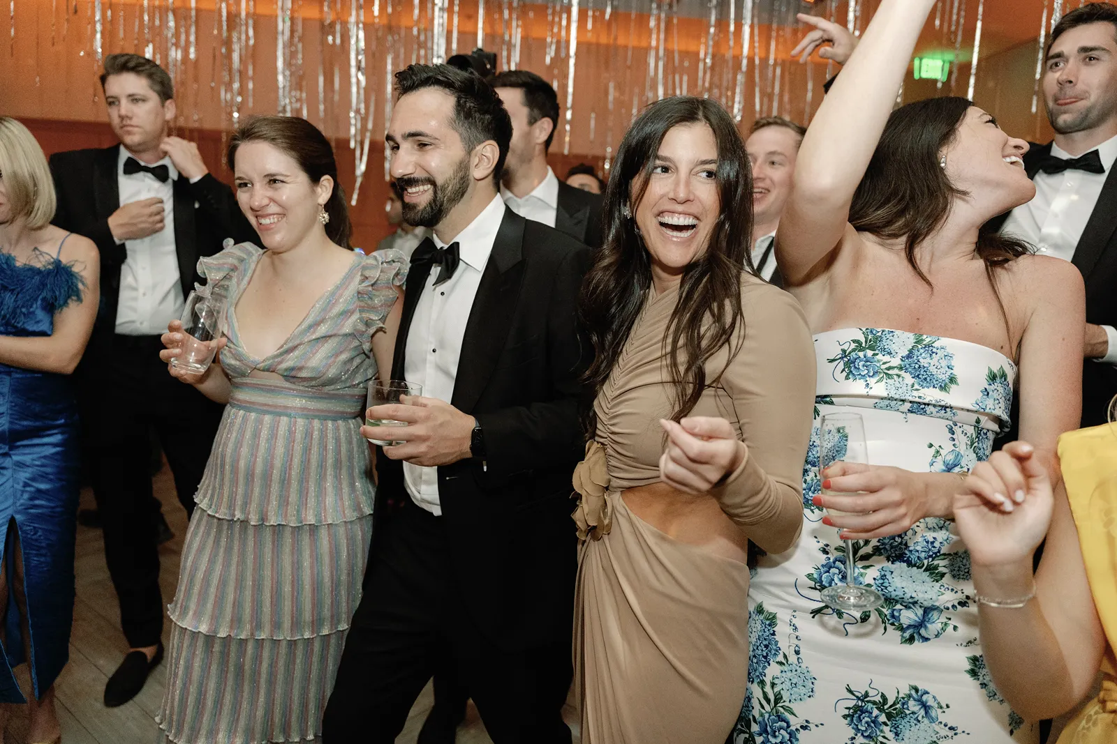 wedding guests laughing and dancing around the dance floor