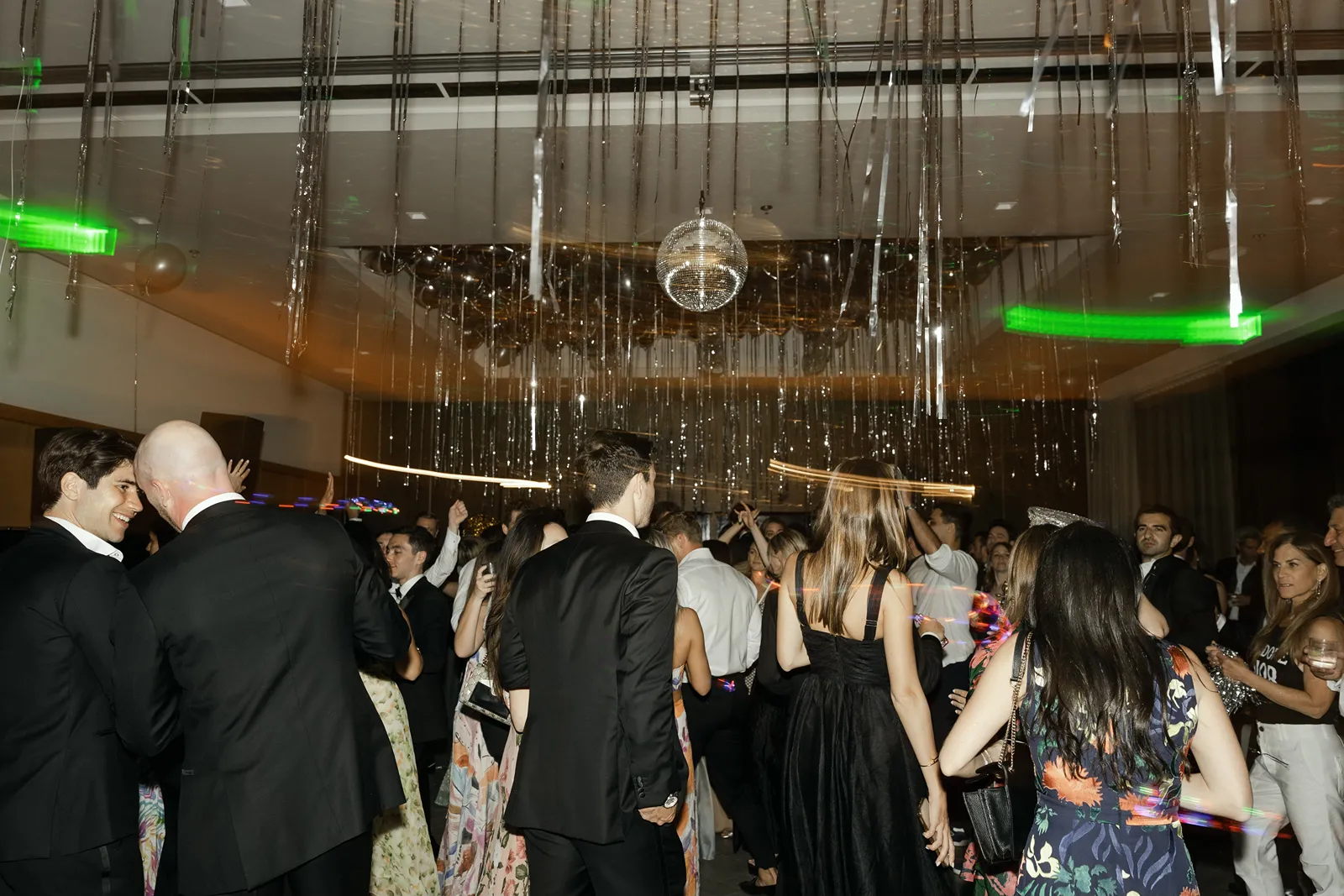 Crowded wedding dance floor under disco ball and hanging streamers at Montage Healdsburg after party
