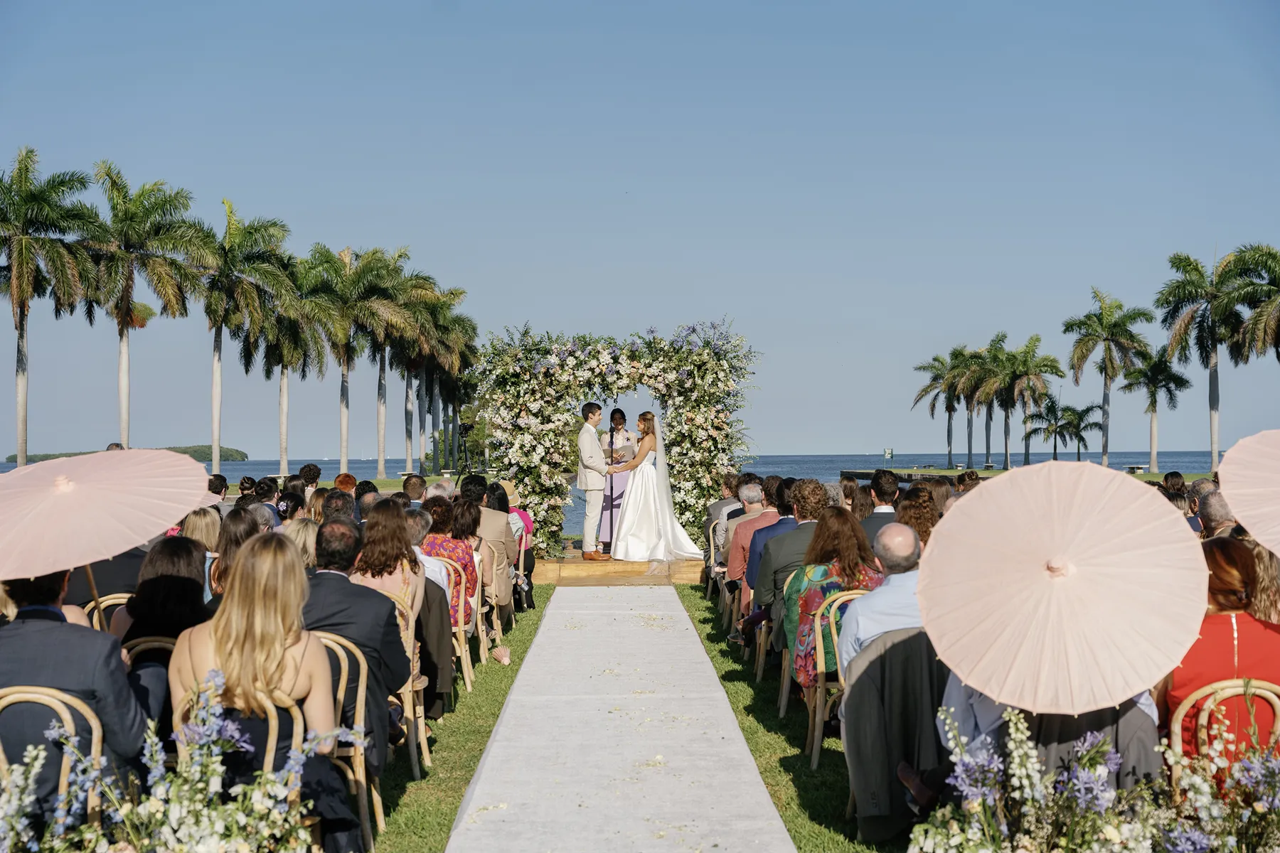 wedding ceremony with floral arch overlooking the water in deering estate