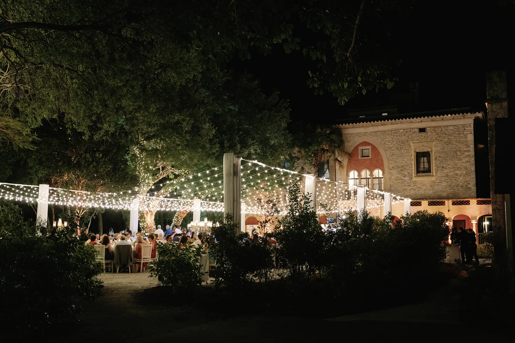 wedding reception view at night covered in hanging lights in deering estate
