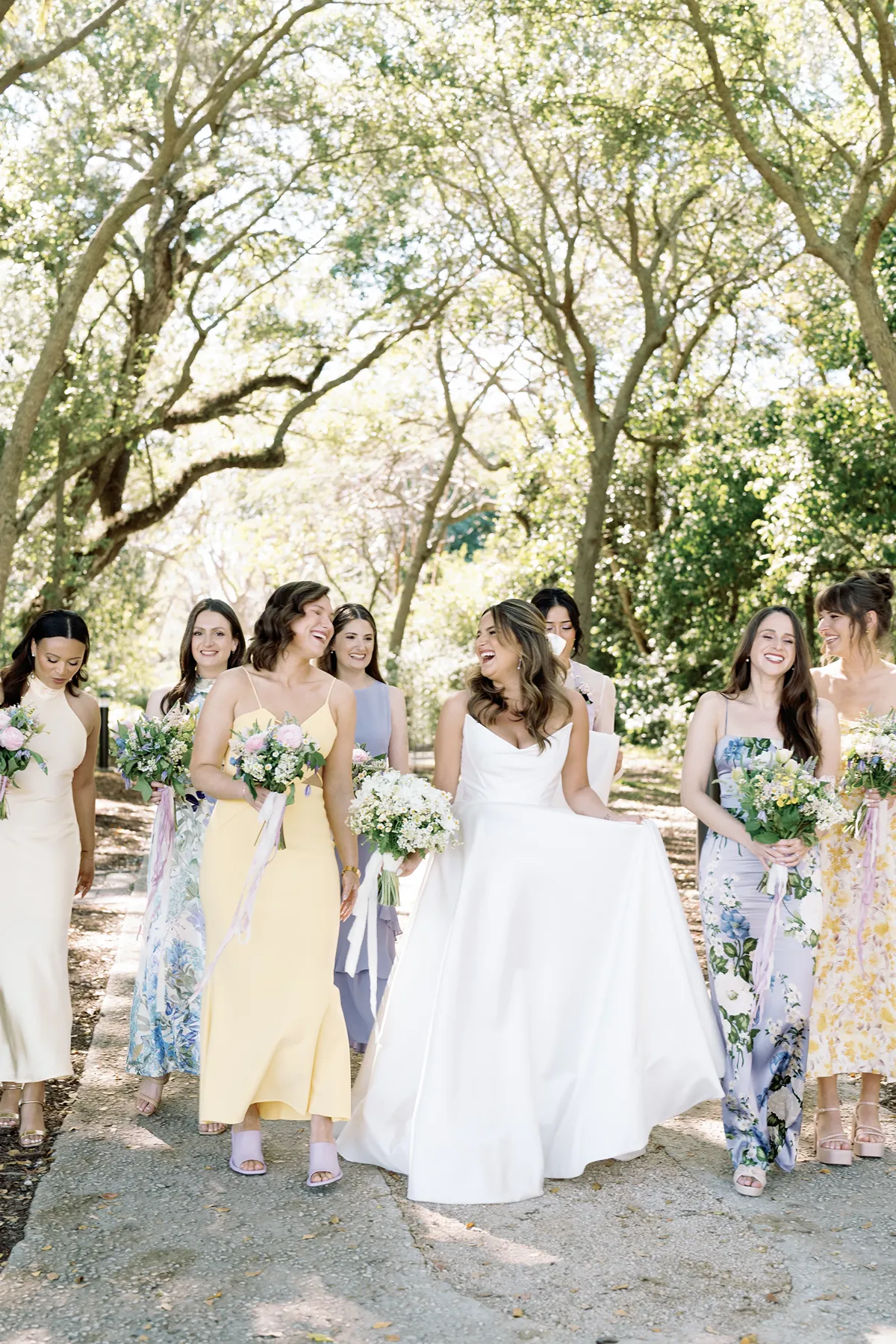 colorful pastel bridesmaids and bride walking and laughing in peering estates