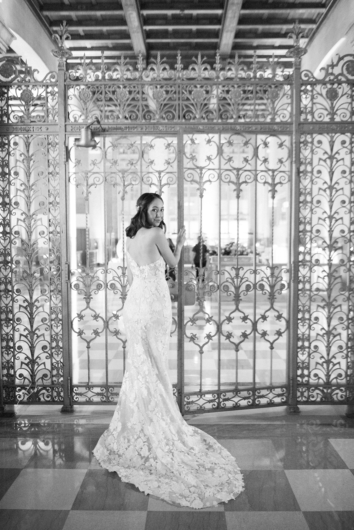 bride against gold metal gate during wedding portraits at the Dupont building
