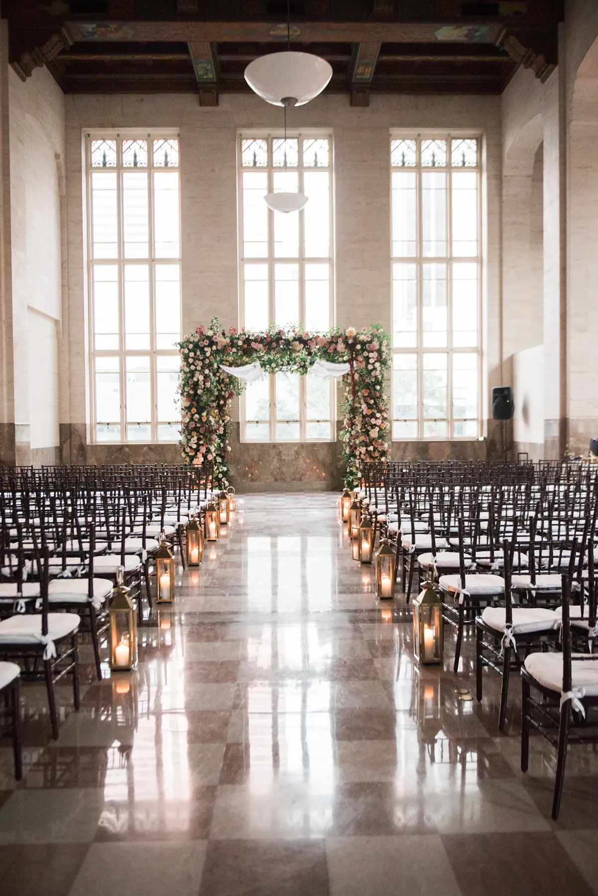 ceremony setup with floral chuppah and wooden chairs in a wedding in the Dupont building in miami