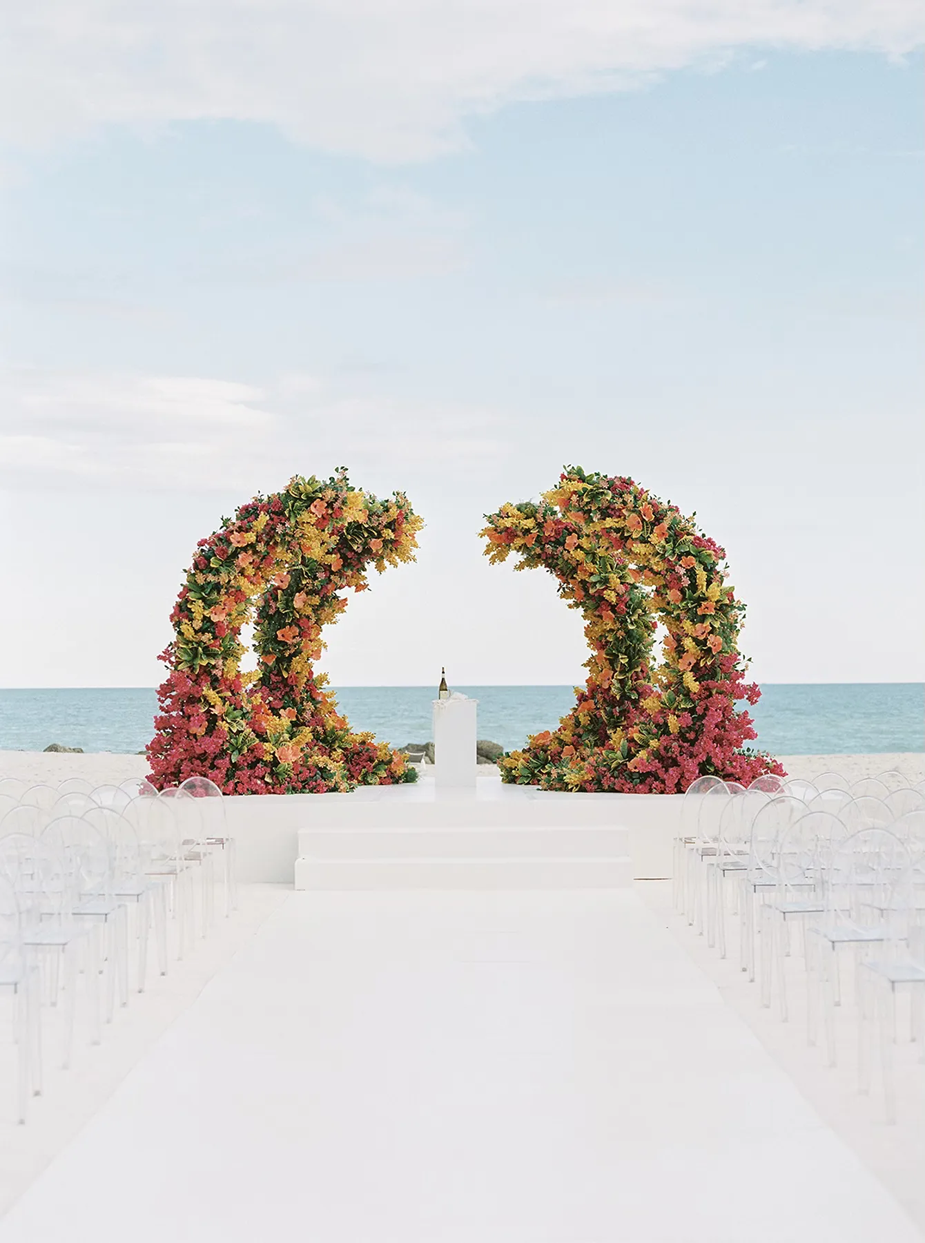 luxury ceremony setup with bright floral arches on the beach during a faena Miami Beach hotel wedding