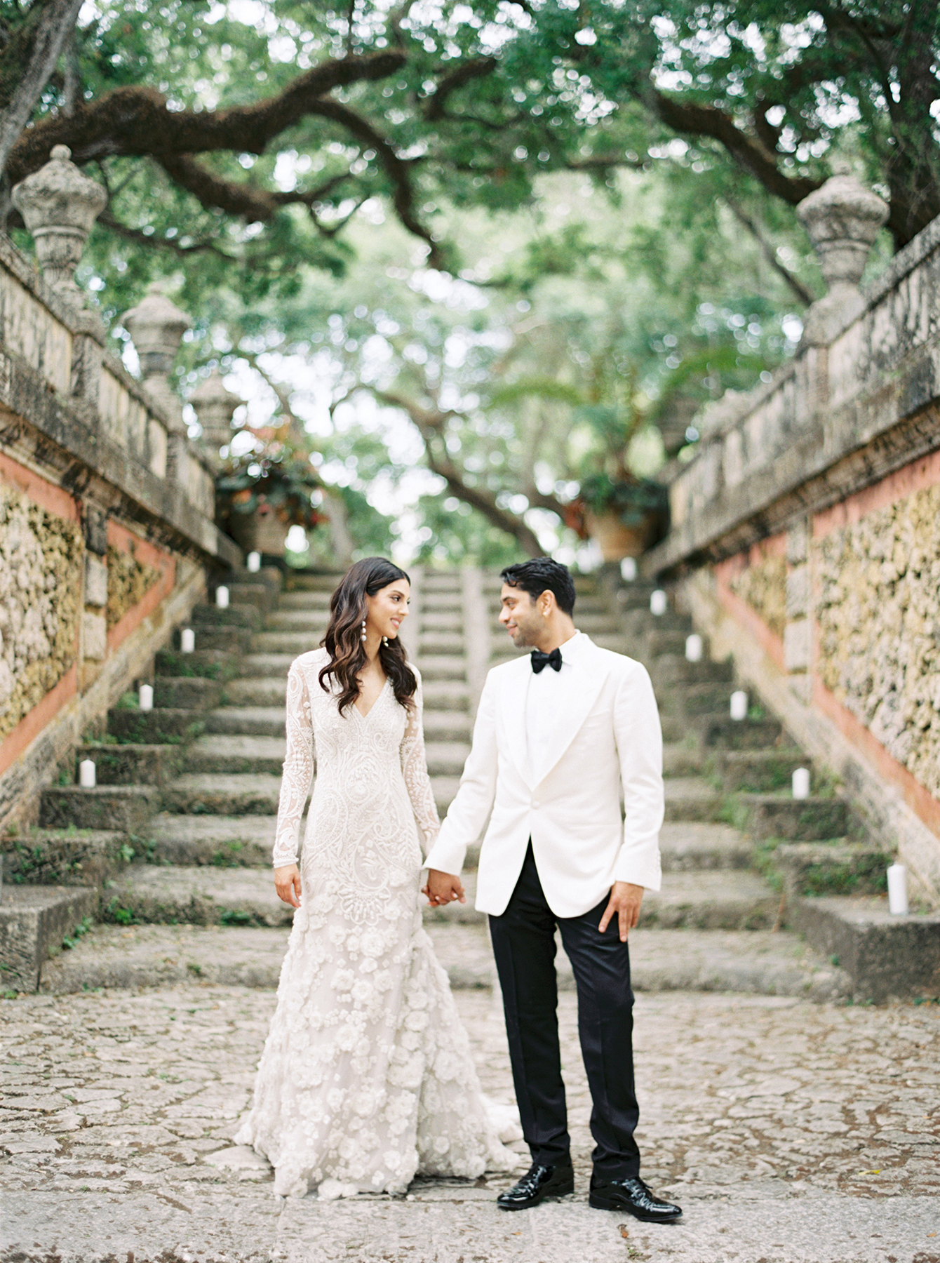 Bride and groom walking together through the gardens at Vizcaya Museum & Gardens