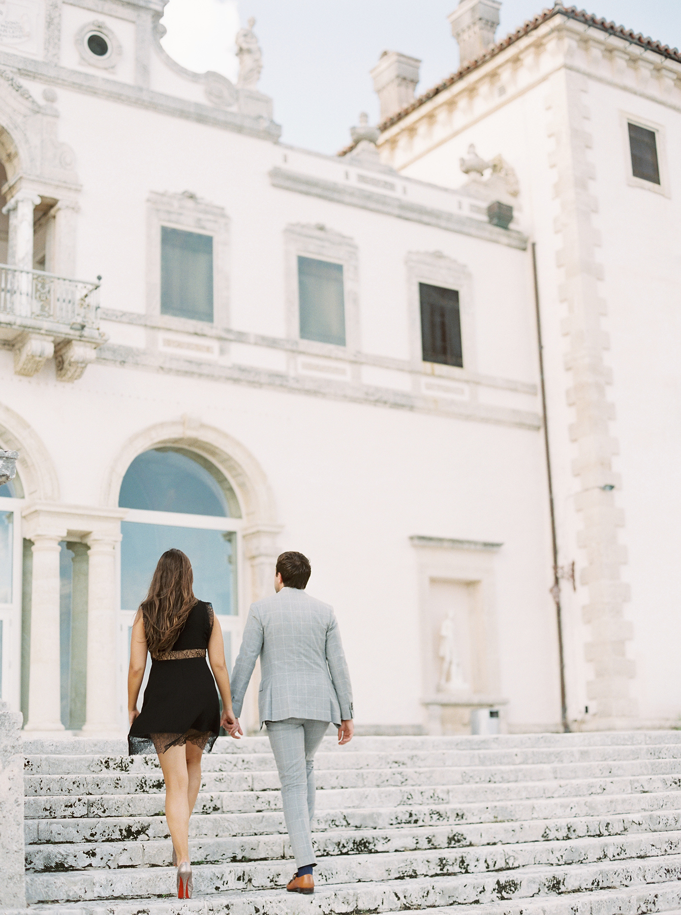 Couple walking up the grand steps of Vizcaya Museum & Gardens in Miami